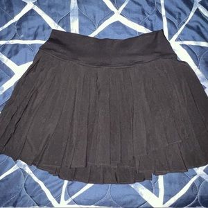 Pleated Tennis Skirt. It is a mini skirt with shorts under that has pockets.